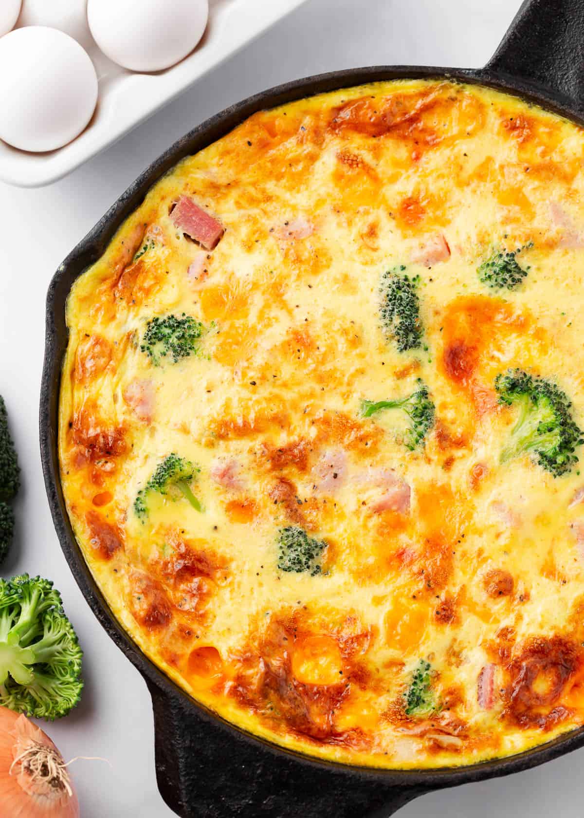 Frittata with ham, cheese and broccoli in an iron skillet.