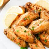 Lemon pepper wings on a platter with parsley.