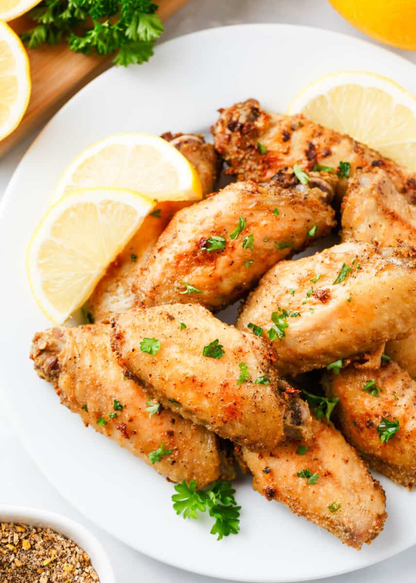 Lemon pepper wings on a platter with parsley.