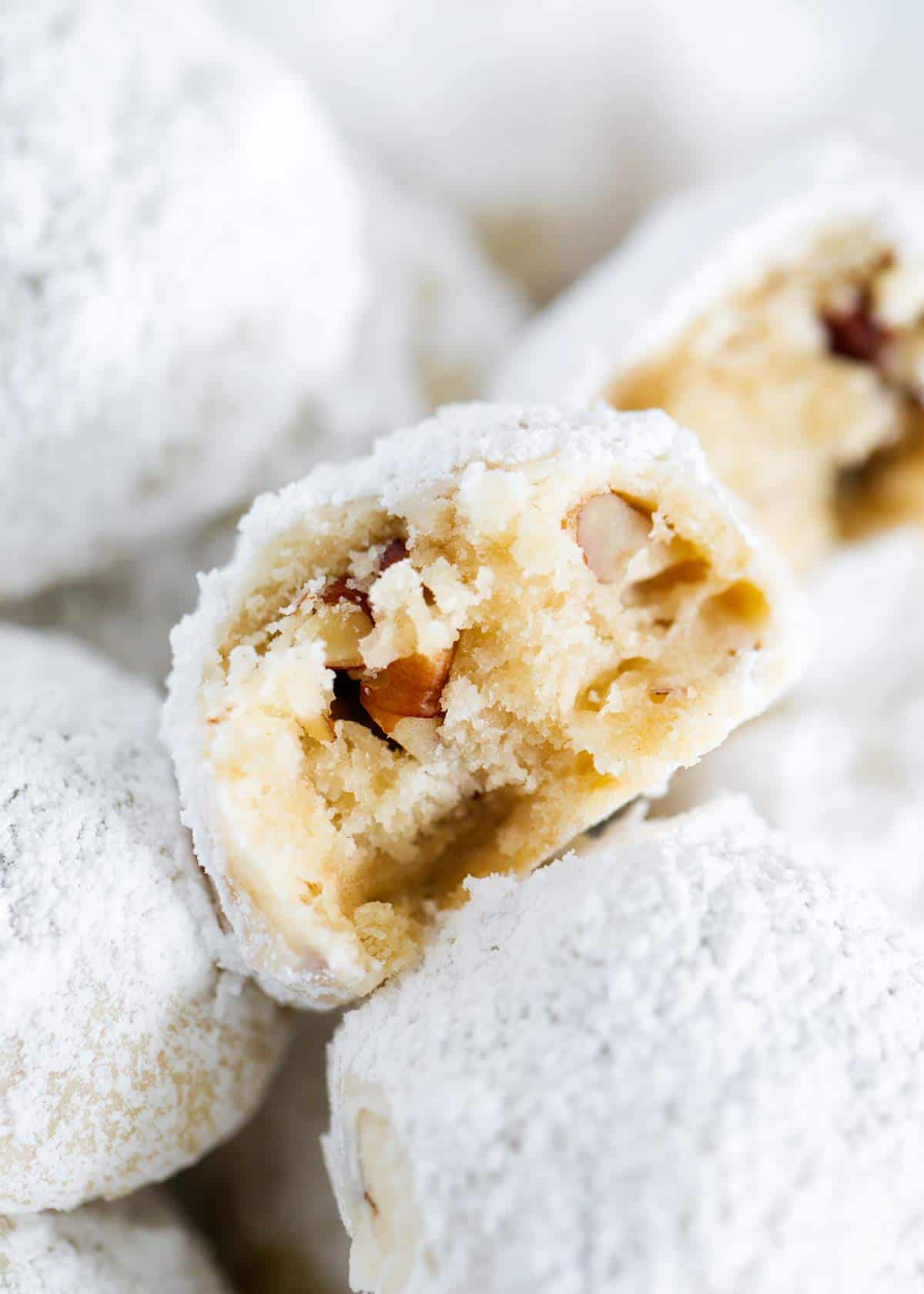 Mexican wedding cookies with a bite taken.