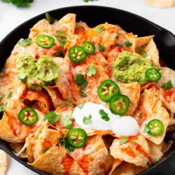 Baked nachos in a cast iron skillet.