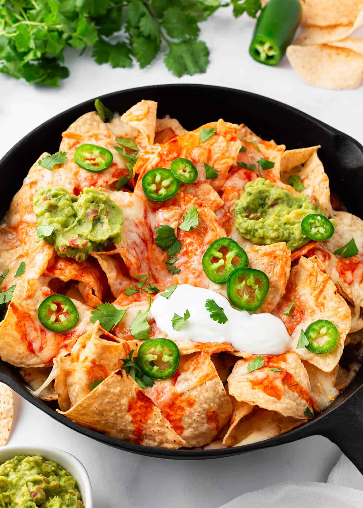 Baked nachos in a cast iron skillet.