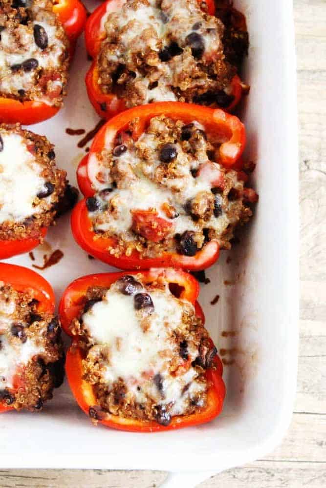 These stuffed bell peppers with quinoa are filled with flavor and simple to make. A delicious, healthy, and quick meal my whole family enjoyed. Quinoa stuffed peppers in a baking dish.