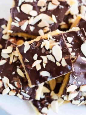 Close-up of chocolate topped saltine toffee pieces sprinkled with sliced almonds.