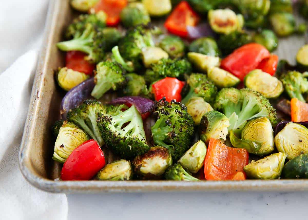 Bring out the natural flavors of your favorite vegetables with customizable sheet pan veggies. This recipe uses Brussels sprouts, bell peppers, onions, and broccoli that are roasted to caramelized, crispy, and tender perfection for a fresh, healthy, and delicious side dish for any main! Roasted vegetables on a sheet pan.