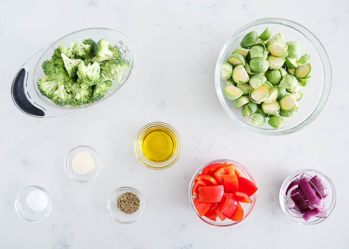 Sheet pan veggies ingredients on marble counter.