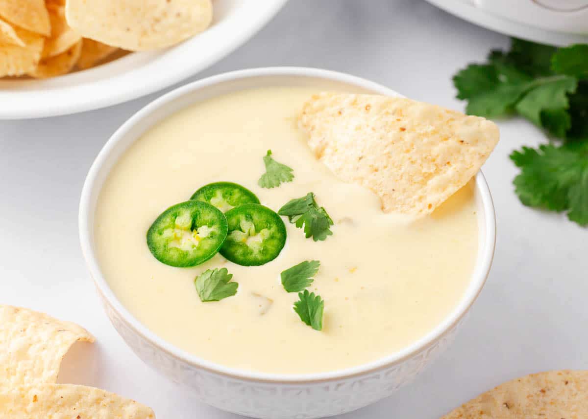 Queso blanco in a white bowl with tortilla chips.