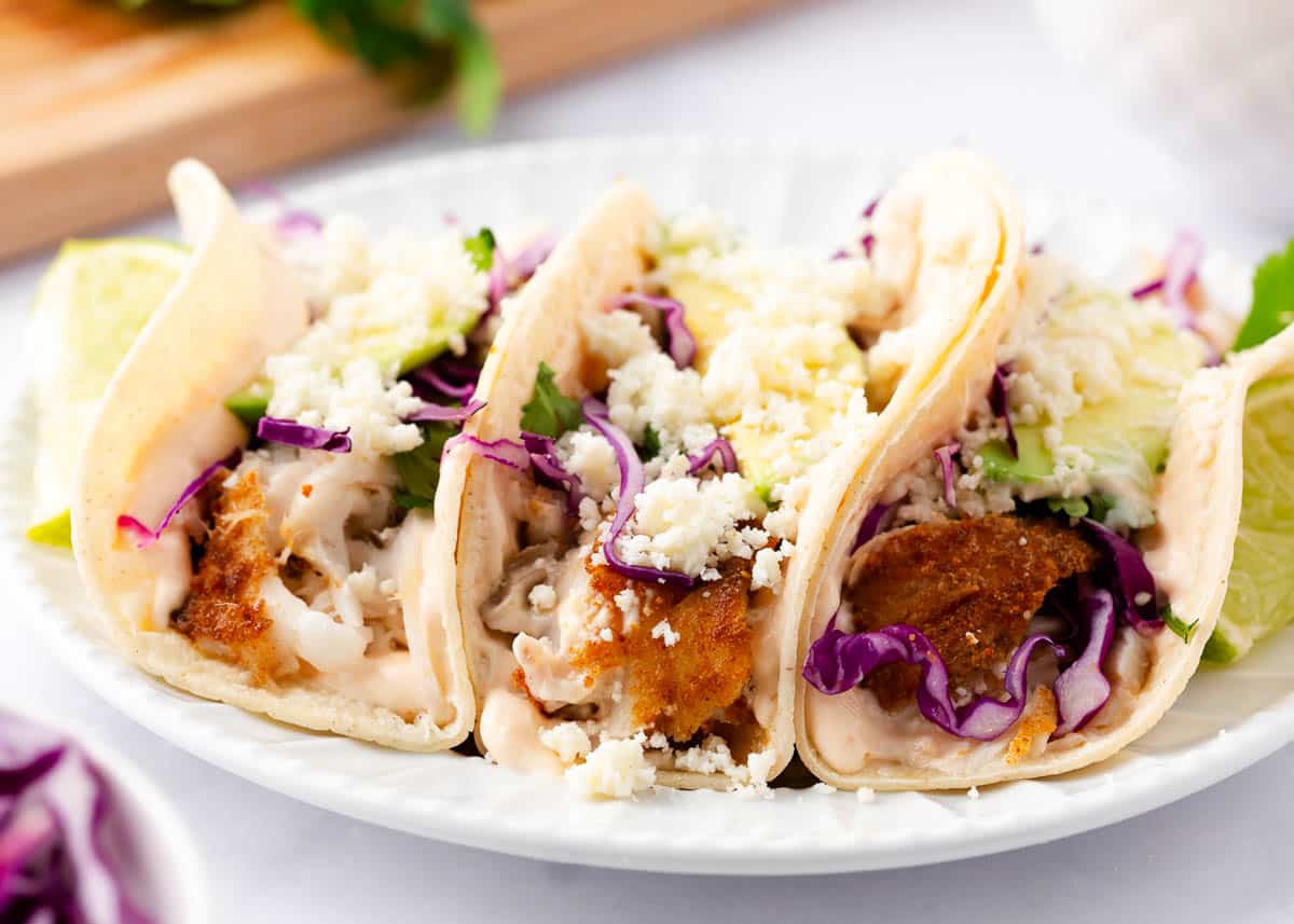 Tilapia fish tacos on a white place.