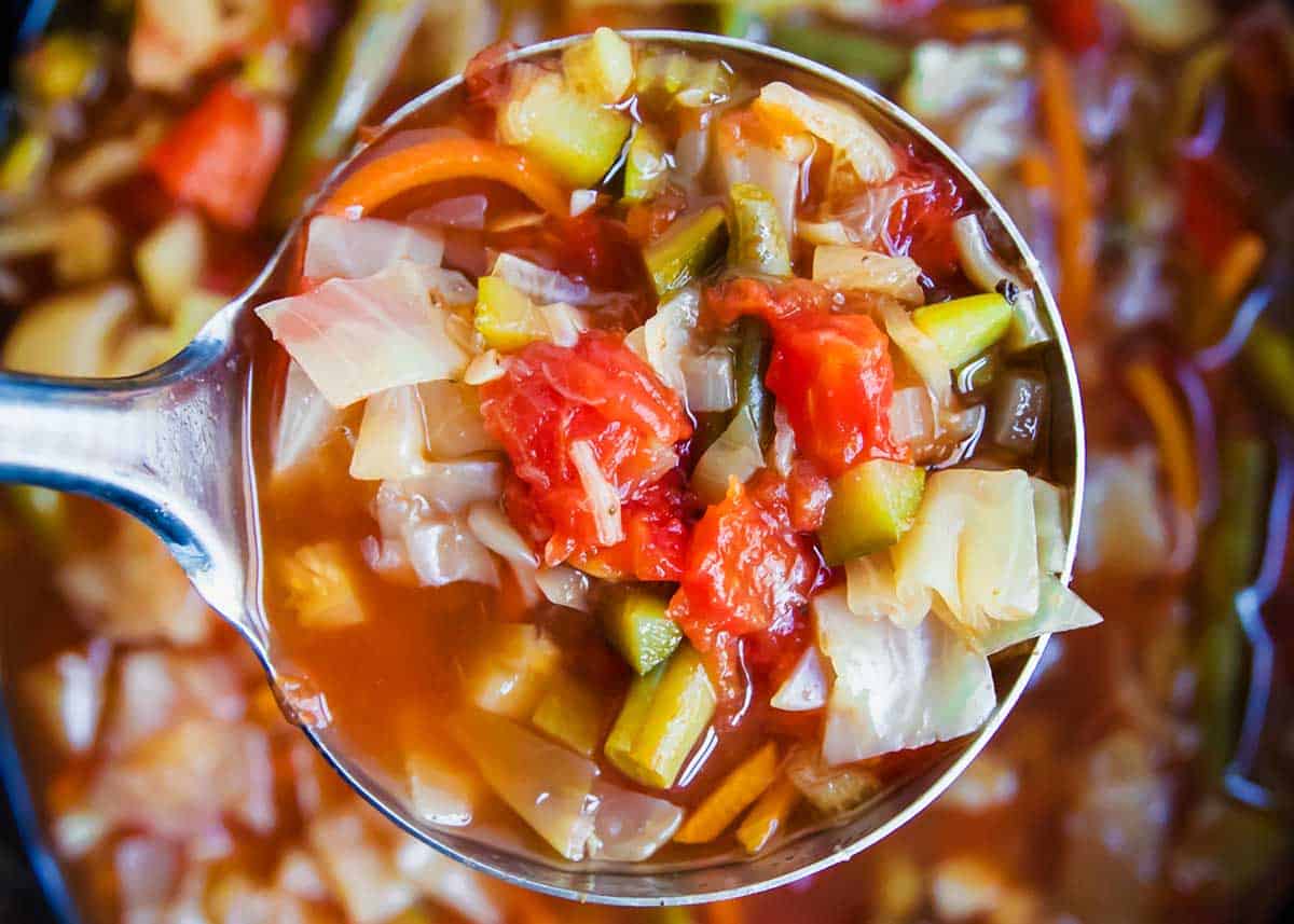 This crockpot cabbage soup is not only delicious and flavorful but chock full of vegetables with lots of fiber and is very satisfying. All you need to do is dump everything in the slow cooker and let it do the work for you! Ladle of cabbage soup.