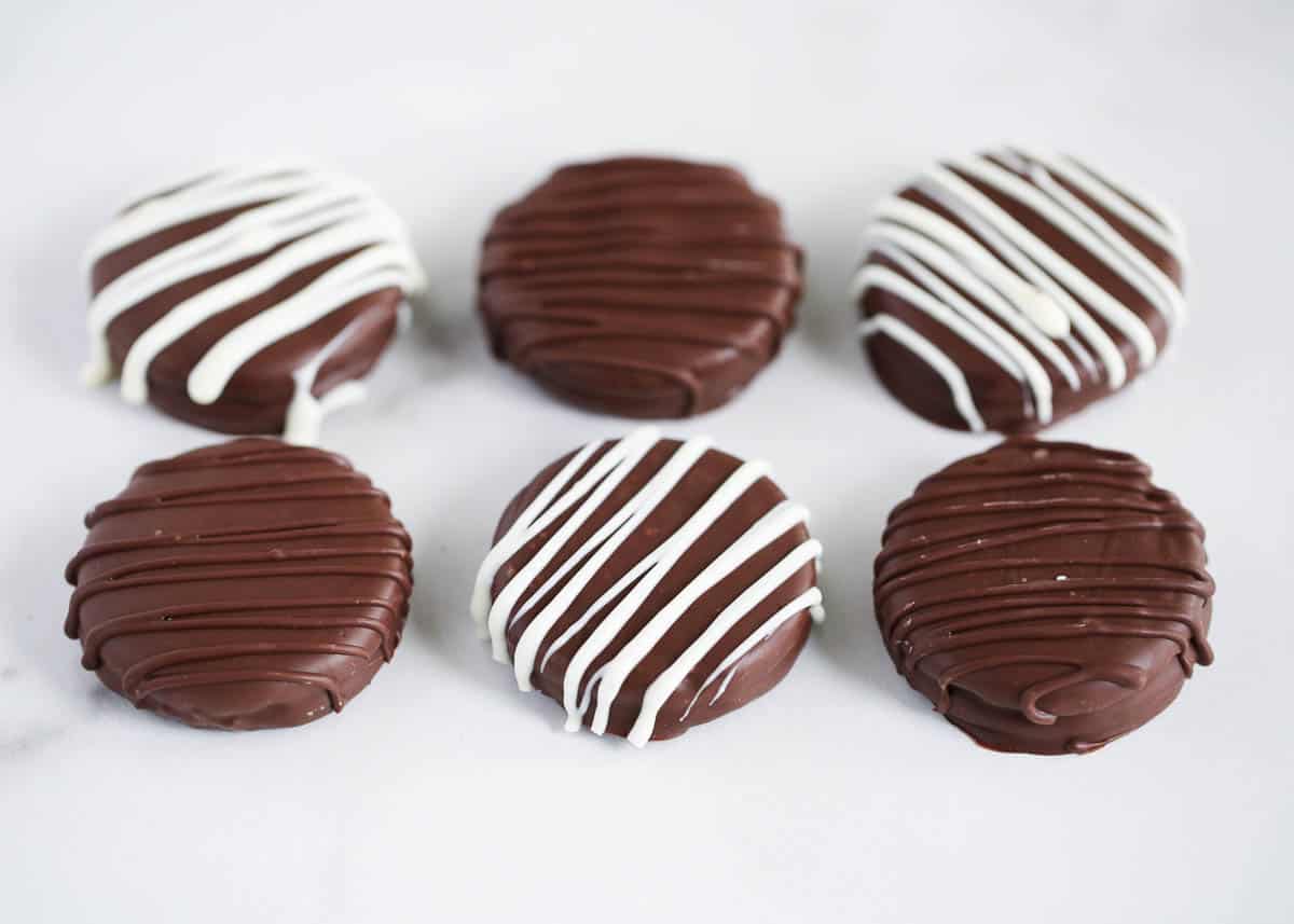 Chocolate covered oreos on the counter.