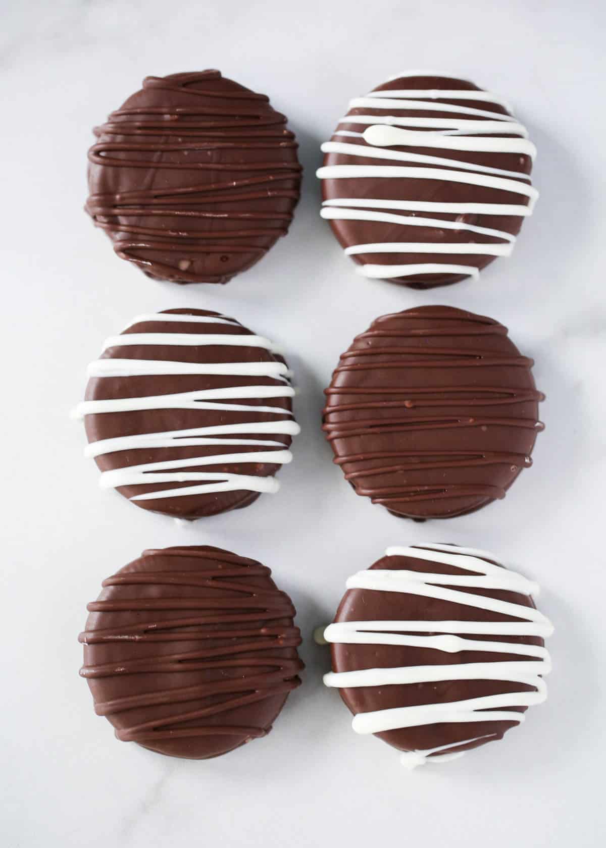 Chocolate covered oreos on the counter.