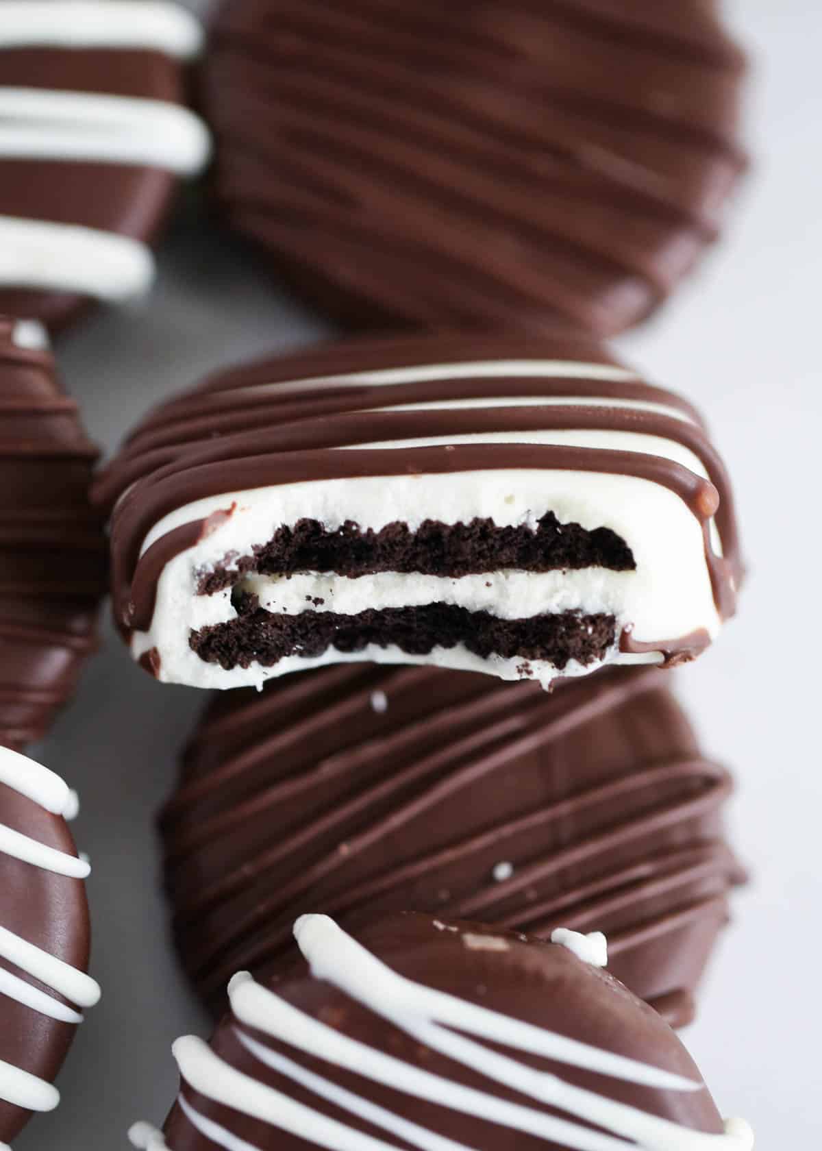 Chocolate covered oreos stacked on the counter.