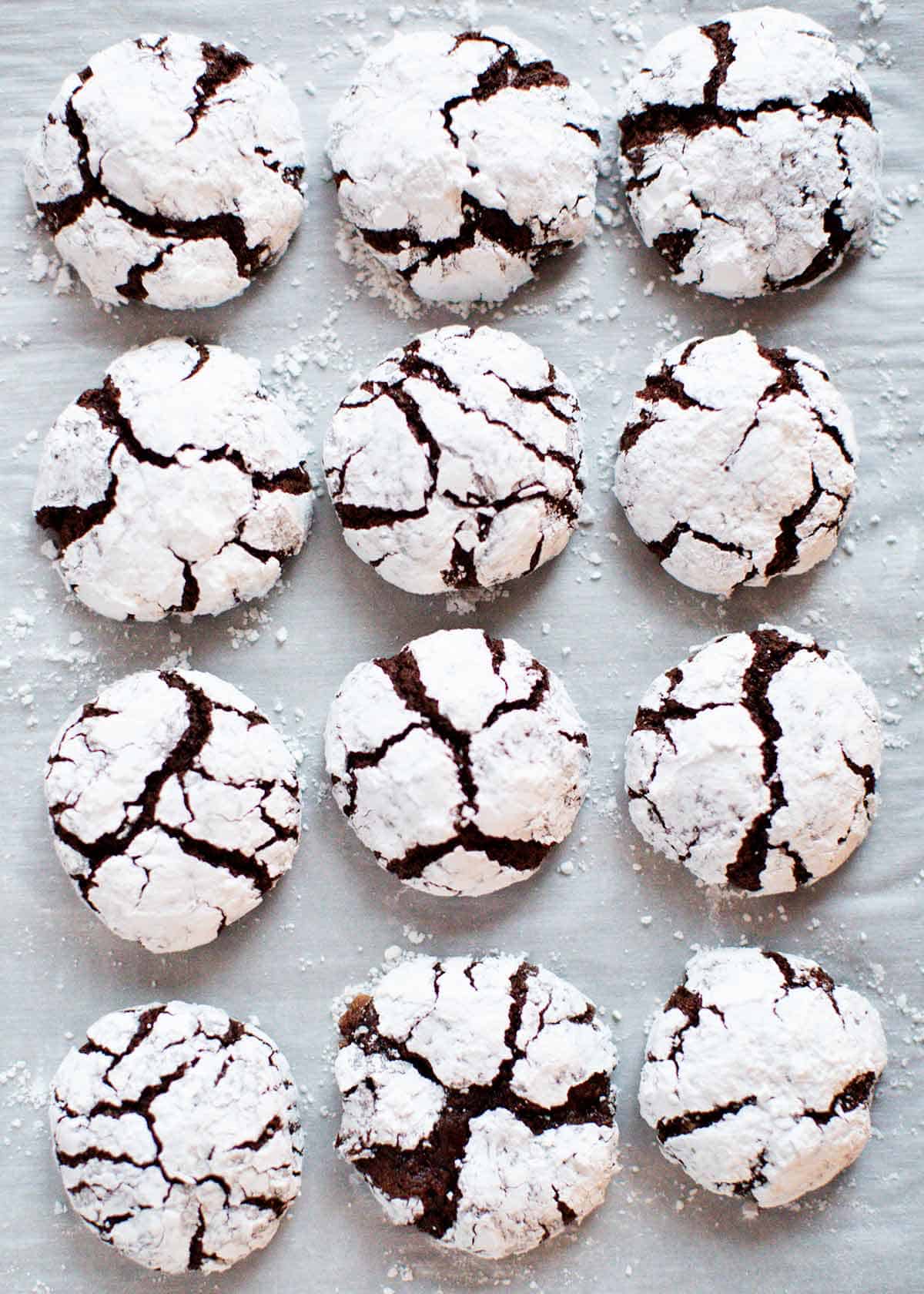Chocolate crinkle cookies on parchment paper. 