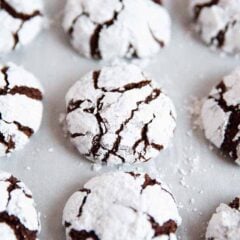 Chocolate crinkle cookies on parchment paper.