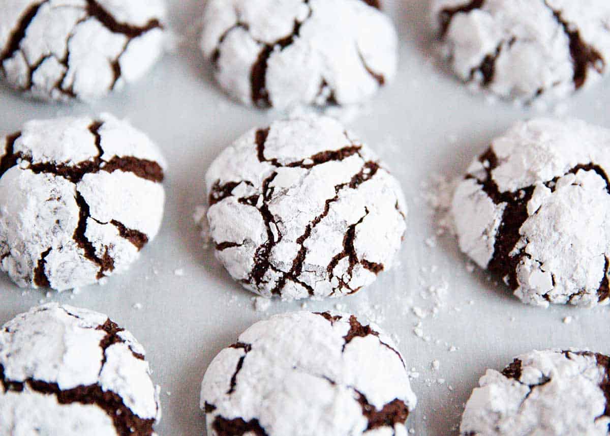 Chocolate crinkle cookies on parchment paper.