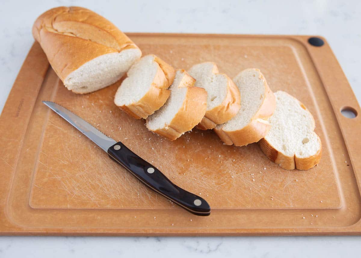 Sliced french bread on cutting board.