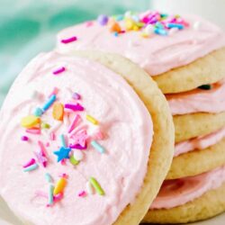 Soft sugar cookies stacked on a white plate.