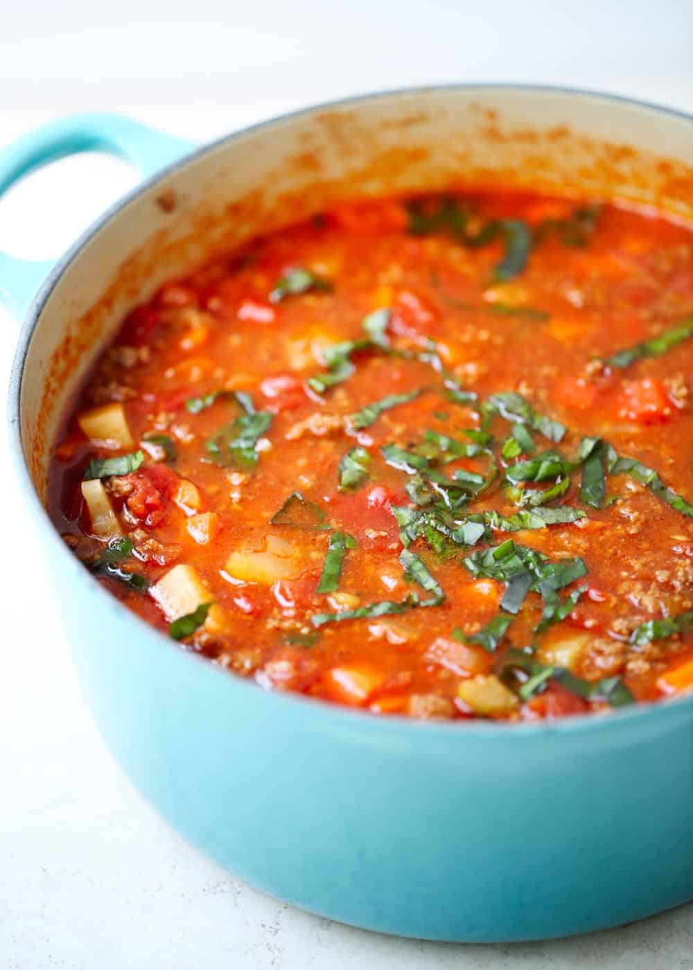 Vegetable beef soup in a blue pot.