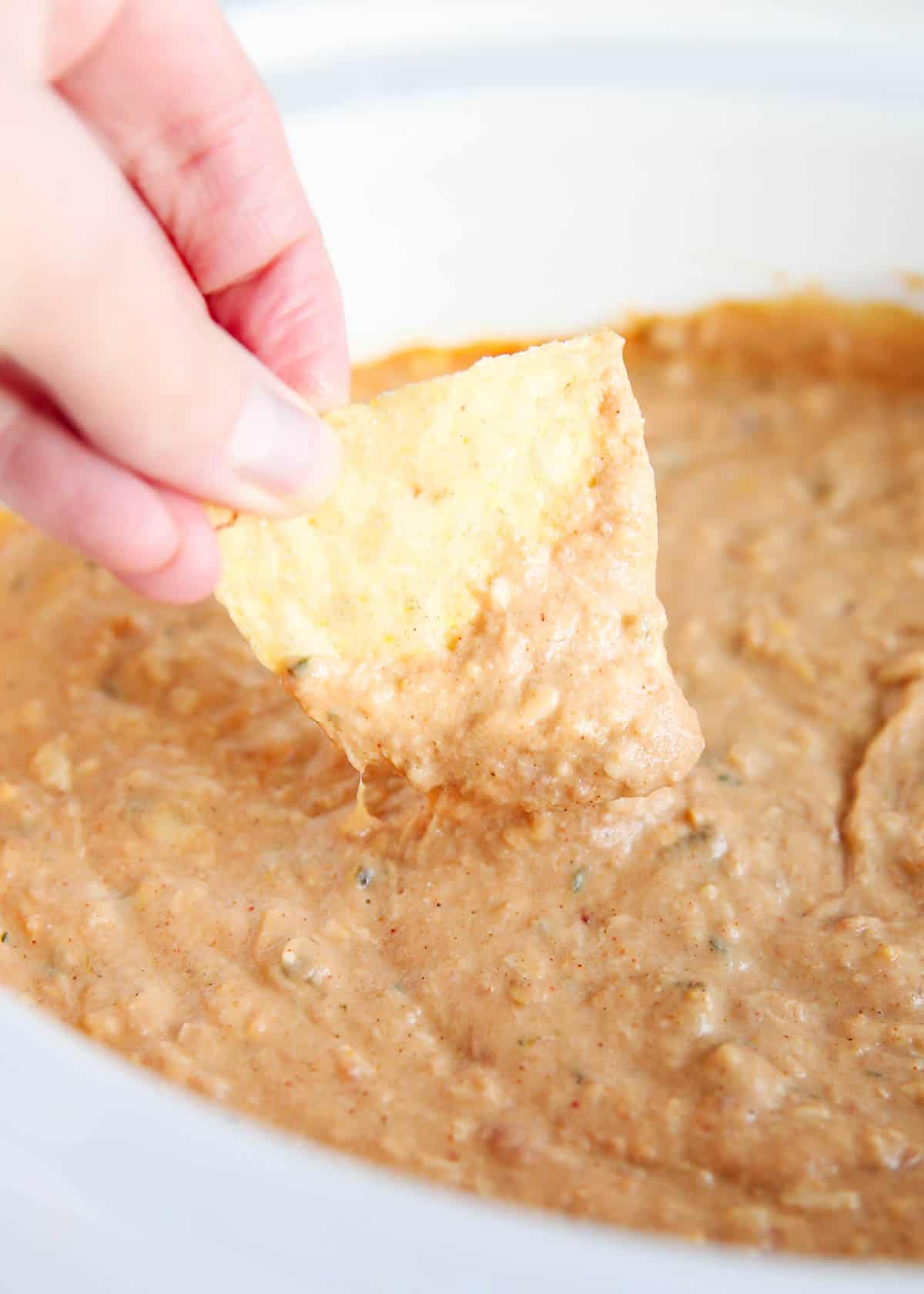 Dipping chip into bean dip.