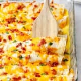 Breakfast enchilada casserole with wooden spoon.