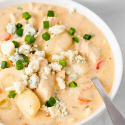 Buffalo chicken soup in a white bowl with spoon.