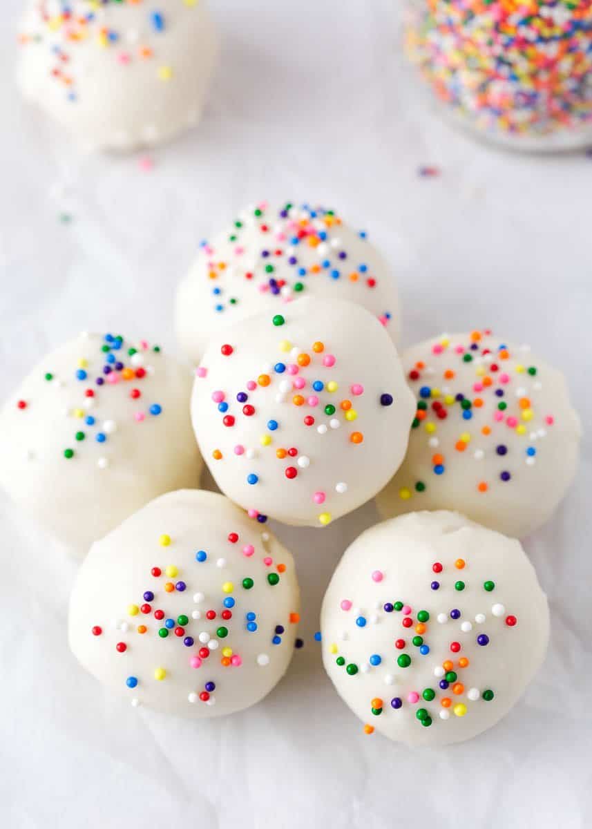 Cake balls with sprinkles stacked on top of a plate.
