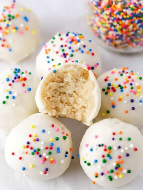 Cake balls with sprinkles and a bite of one taken.