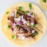 Carnitas meat on corn tortilla.