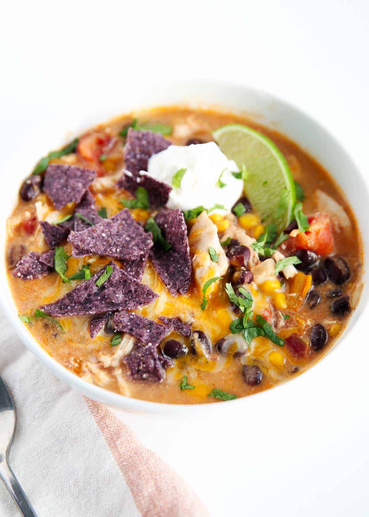 Chicken enchilada soup in white bowl.