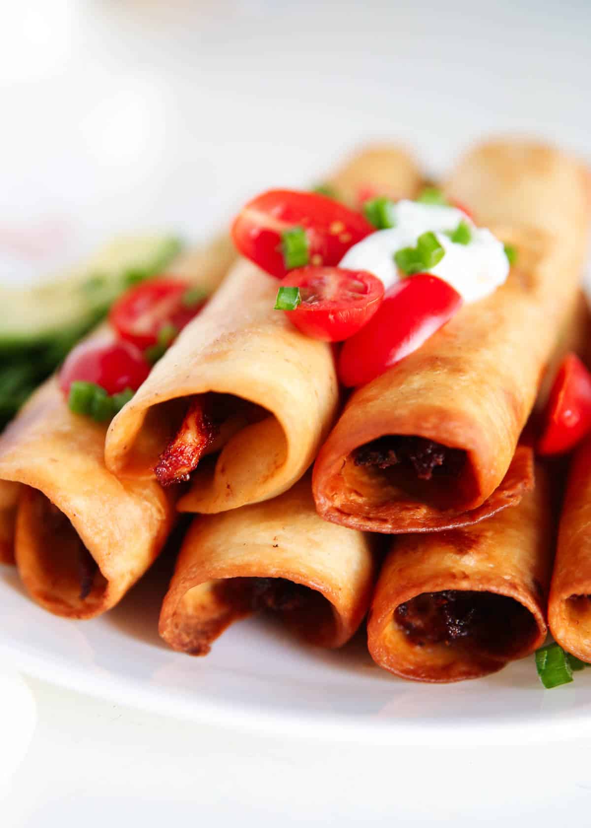 Chicken flautas on a white plate.