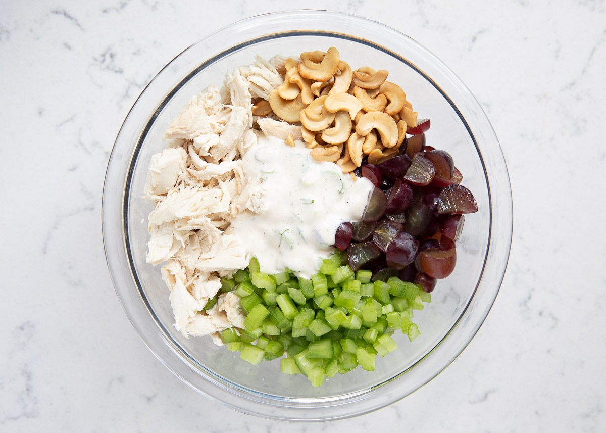 Chicken salad ingredients in a glass bowl. 