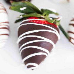 Chocolate covered strawberry on a white plate.