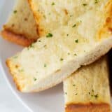 Sliced garlic bread on a white plate.