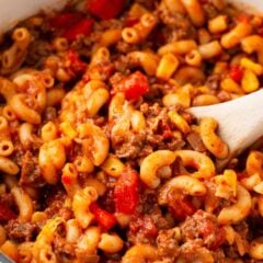 Easy American goulash made with ground beef, elbow noodles, and tomato sauce cooking in a pot.