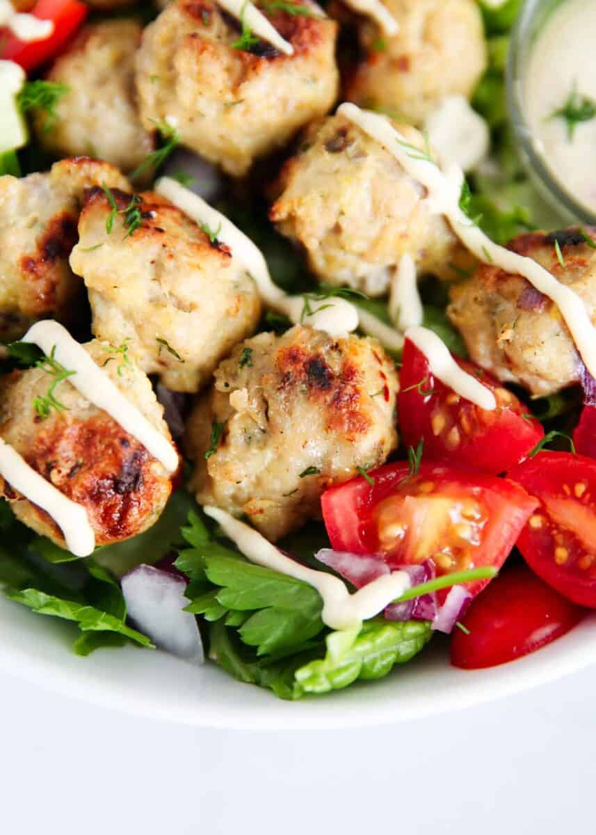Greek chicken meatballs and a salad in a bowl.