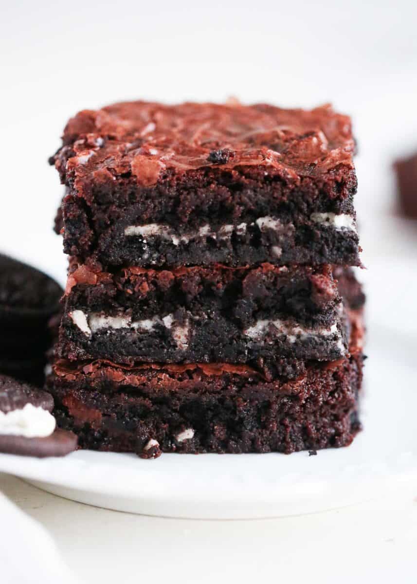 Three stacked Oreo brownies on a white plate.