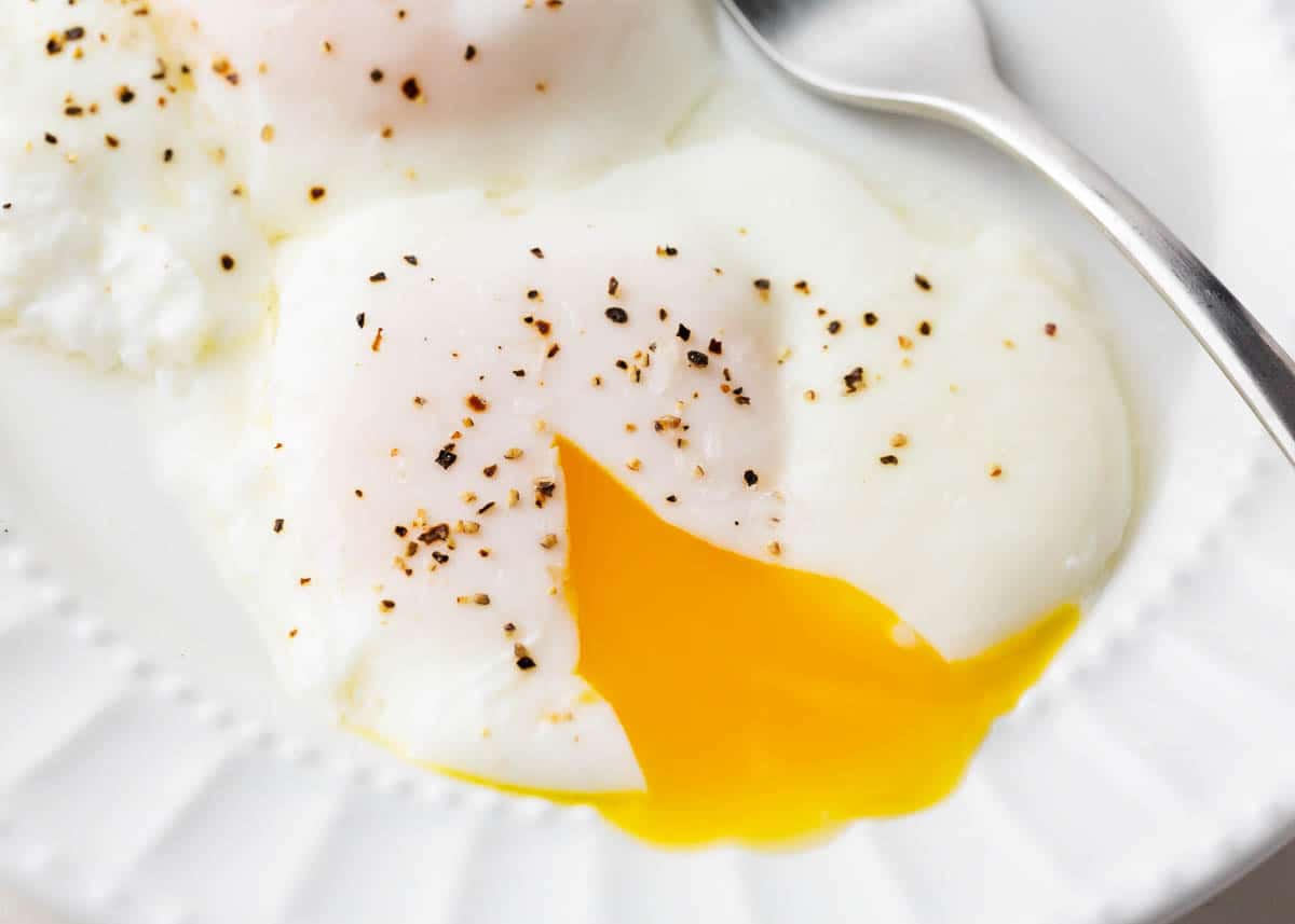 Poached eggs on white plate.