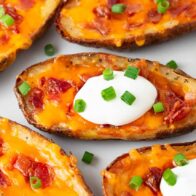 Potato skins with sour cream and green onions on top.