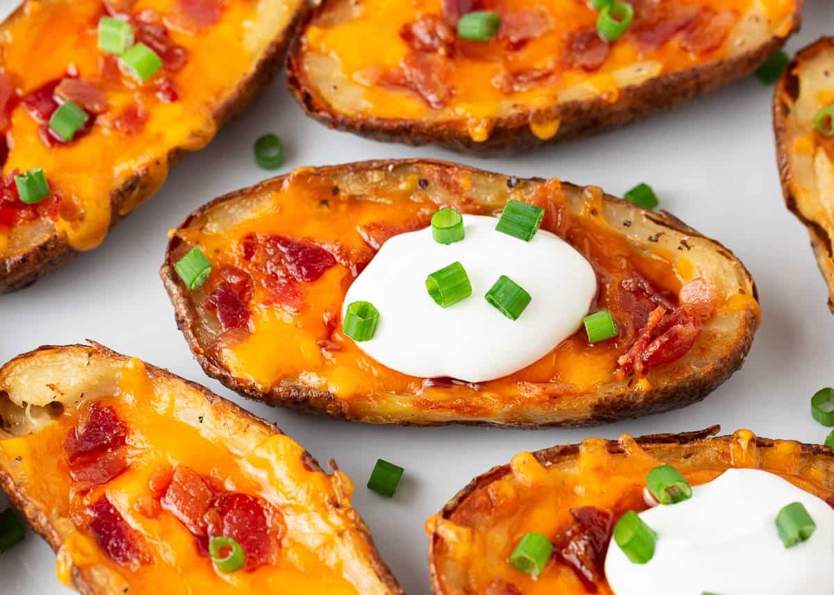 Potato skins with sour cream and green onions on top.