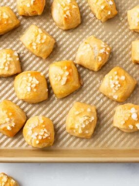 Pretzel bites on gold baking sheet.