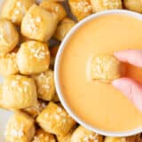 Dipping pretzel bites into cheese sauce.