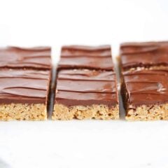 Scotcheroos with chocolate butterscotch topping cut into squares on counter.