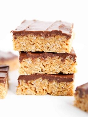 Stack of Scotcheroos on white counter showing soft and chewy texture and chocolate topping.