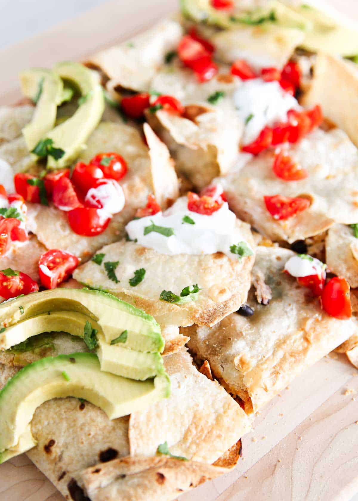 Sheet pan quesadilla on a wooden platter.