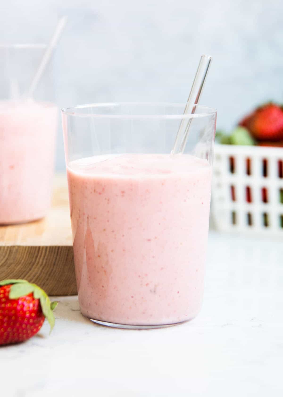 Strawberry banana smoothie in a glass cup on counter.