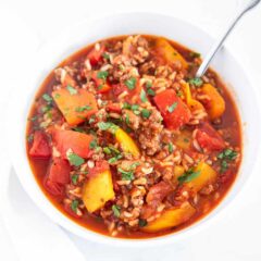 Stuffed pepper soup served in a white bowl with a spoon.