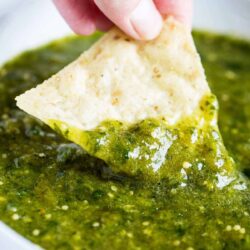 Salsa verde being dipped with a chip.