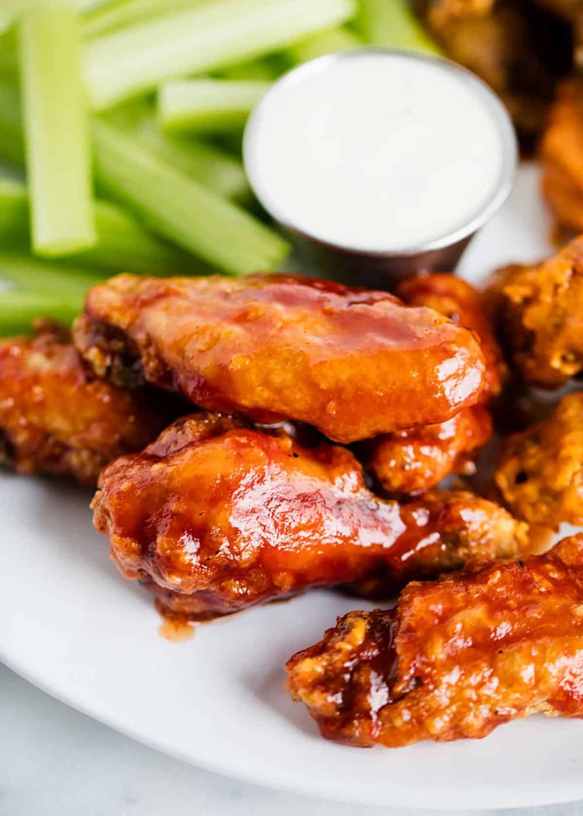 Baked chicken wings on a plate with celery.