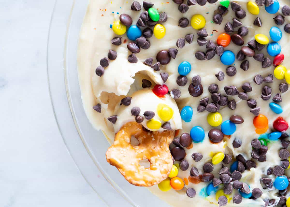 This cheesecake dip is super creamy, rich and completely addicting. It is the ultimate no-bake dessert and SO easy to make! Customize with your favorite mix-in's and dippers. Cheesecake dip in a glass dish.
