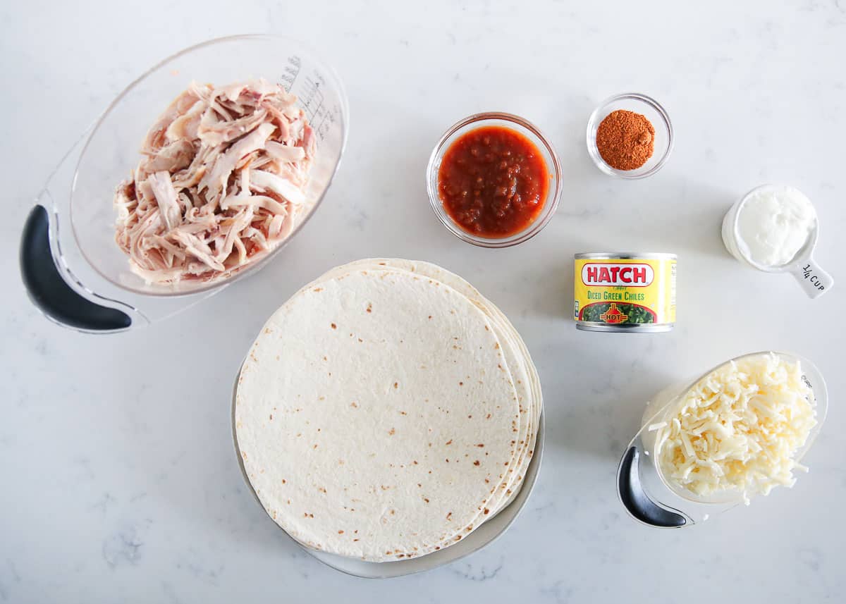 Chicken flautas ingredients on marble counter.